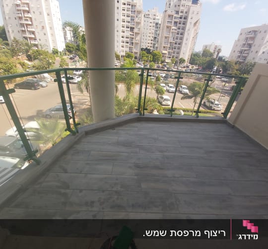מרפסת עם רצפת אריחים חדשה ומעקה זכוכית